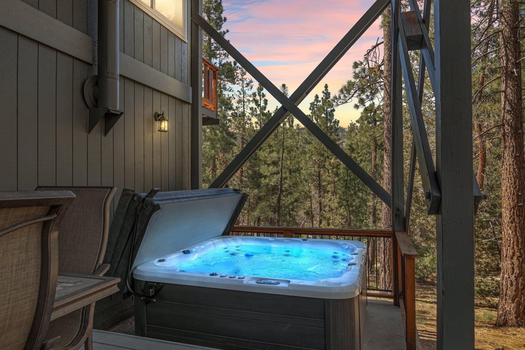 Hot tub on a covered deck under a pink dusk sky