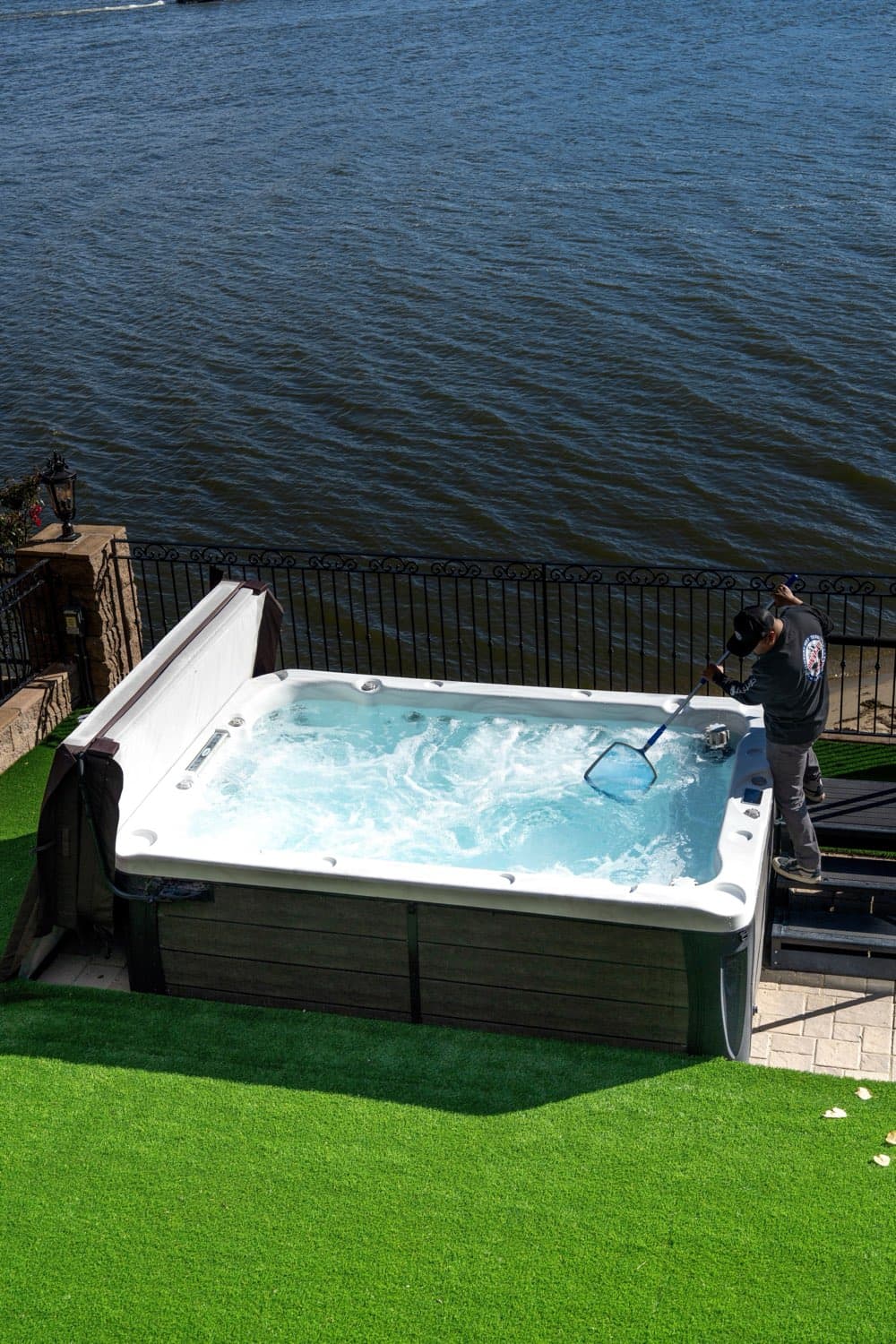 A Pinnacle Tubs swim spa being serviced at the lakefront